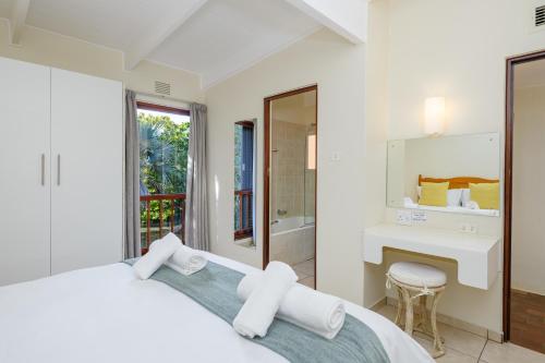 a white bedroom with a bed and a desk at San Lameer Villa 3501 - 2 Bedroom Classic - 4 pax - San Lameer Rental Agency in Southbroom