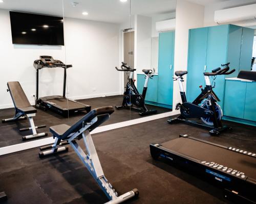een fitnessruimte met diverse hometrainers in een kamer bij Peninsula Hotel Motel in Adelaide