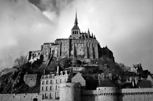 a large castle sitting on top of a mountain at Edel de la Touche Balard in Val Couesnon