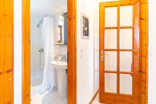 a bathroom with a sink and a shower and a door at Apartment corfu in Lefkímmi