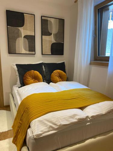 a bedroom with a large bed with a yellow blanket at Design Residence Nellere II in Padola