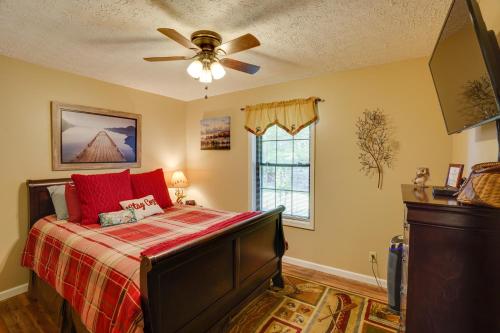 - une chambre avec un lit doté d'oreillers rouges et d'un ventilateur de plafond dans l'établissement Cadiz Vacation Home with Deck Walk to Lake Barkley, à Cadiz