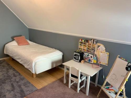 a small bedroom with a bed and a table at Stort hus i Stockholm in Sollentuna