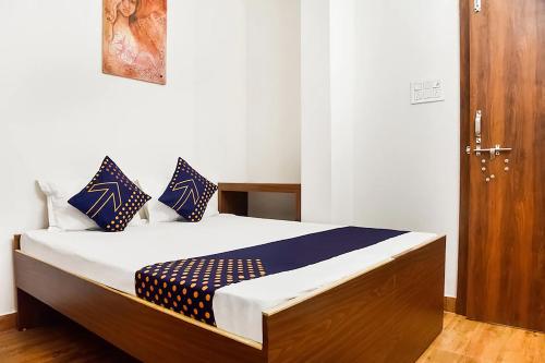 un letto con cuscini blu e bianchi in una stanza di Hotel Saubhagya a Bhopal