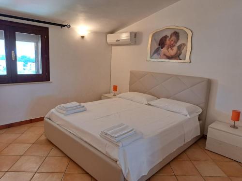 a bedroom with a large white bed with towels on it at La dimora del Sole in Scicli