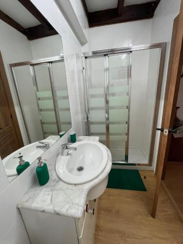 a white bathroom with a sink and a shower at La Casa de Sabina in Lon