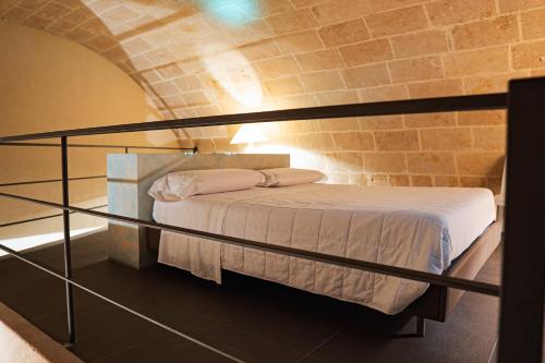 a bed in a room with a brick wall at Ai Quarti Sottani in Matera