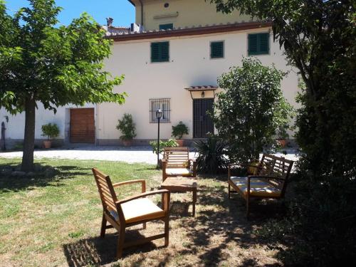 Simplistic Holiday Home in Pistoia with Terrace Garden في بستويا: جلسة مجموعة كراسي أمام المبنى
