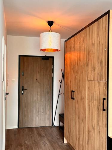 a hallway with a wooden door and a chandelier at SLASKA 12 in Gdańsk