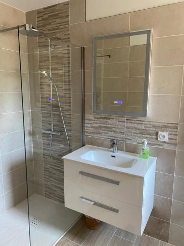 een badkamer met een wastafel en een glazen douche bij Sous le Tilleul in Saint-Maurice-de-Cazevieille