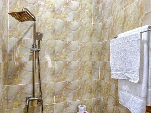 y baño con ducha y azulejos de mármol. en Cozy Apartment - Hideaway with 5G WiFi, en Abuja