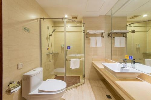 a bathroom with a toilet and a shower and a sink at Unitour Hotel, Nanning Dongge Traditional Chinese Medicine No 1 Affiliated in Nanning