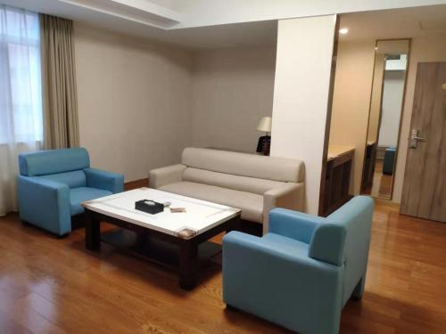 a living room with a couch and two chairs and a table at Unitour Hotel, Nanning Dongge Traditional Chinese Medicine No 1 Affiliated in Nanning