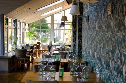 a restaurant with tables and chairs and a wall of windows at The Glen Mhor Apartments in Inverness