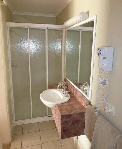 a bathroom with a sink and a shower at Inverloch Central Motor Inn in Inverloch
