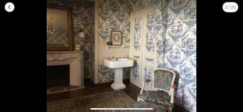 niebiesko-biała łazienka z umywalką i krzesłem w obiekcie Suite privée bleu au château de la Franceule w mieście Janzé