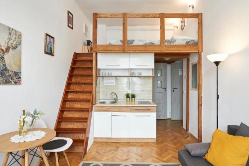 a tiny apartment with a loft bed and a kitchen at Apartments on Miodowa in Kraków