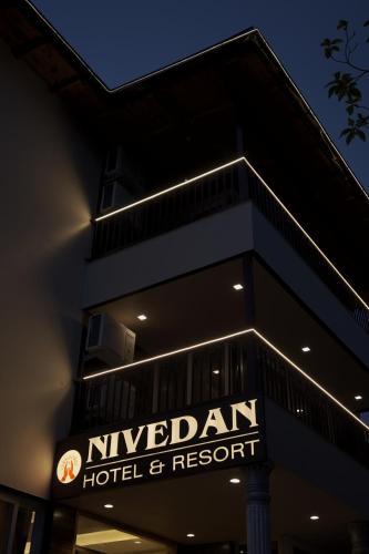 a hotel and resort sign in front of a building at NIVEDAN HOTEL AND RESORT in Nainital