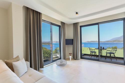 a living room with a white couch and large windows at Kaktus Suites in Kas