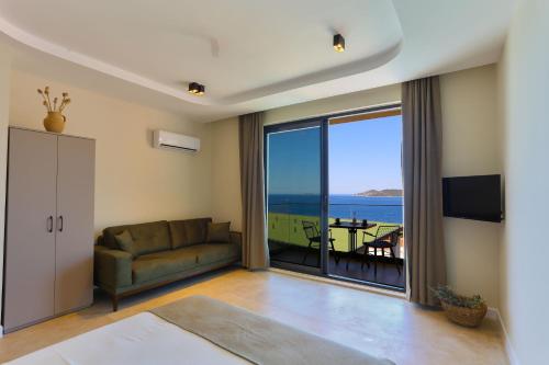 een woonkamer met een bank en uitzicht op de oceaan bij Kaktus Suites in Kas