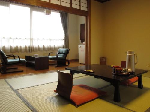 a living room with a table and chairs at Sakaeya Hotel in Tendo