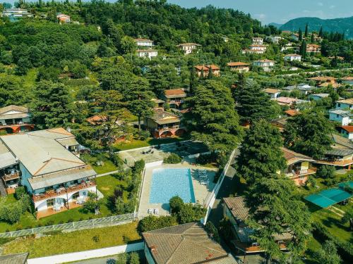 拉法的住宿－Apartment on Lake Garda with pebble beach pier for boat three swimming pools，享有村庄的空中景致,设有游泳池和房屋。