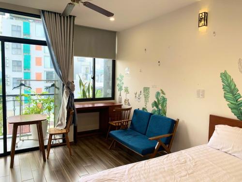 a bedroom with a bed and a desk and a window at Koi Apartment in Da Nang