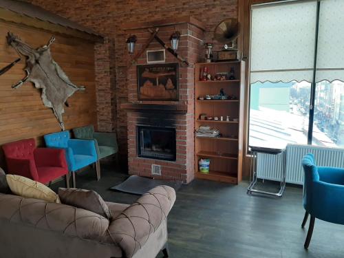 sala de estar con sofá y chimenea en Hotel kafkasya, en Kars