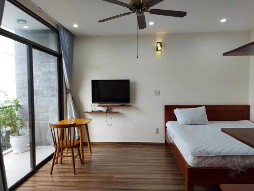 a bedroom with a bed and a flat screen tv at Koi Apartment in Da Nang