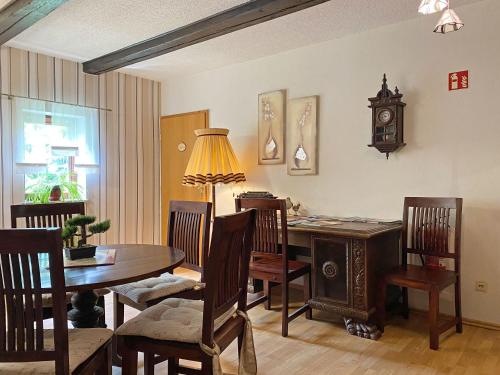 a dining room with a table and a clock on the wall at RATAGS Kunsthandwerkerhaus in Langenwolmsdorf