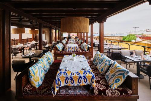 a dining room with a table and pillows at Kosh Havuz boutique hotel in Samarkand