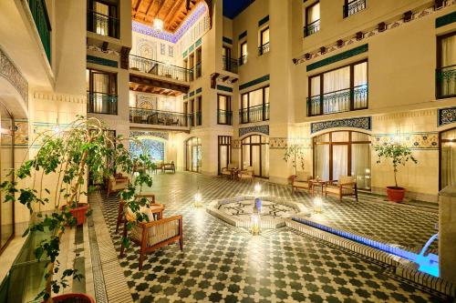 an indoor courtyard with a fountain in the middle of a building at Kosh Havuz boutique hotel in Samarkand