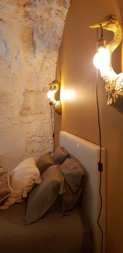 a bedroom with two lamps and a bed with pillows at Les Troglos de la Tufolière in Rochecorbon