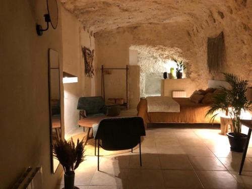 a bedroom with a bed and a table and chairs at Les Troglos de la Tufolière in Rochecorbon