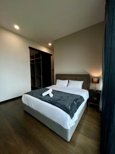 a bedroom with a large bed with a black blanket at Opus Residence KL by EUcation Home in Kuala Lumpur