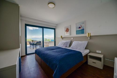 Schlafzimmer mit einem Bett und Blick auf einen Balkon in der Unterkunft Apartments Sea & Stone in Malinska