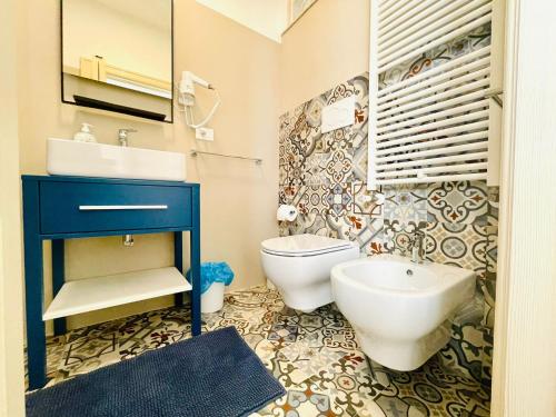 a bathroom with a blue sink and a toilet at CASA GIOBERTI in Castellana Grotte