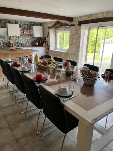 ein Esszimmer mit einem langen Tisch und Stühlen in der Unterkunft Chambres d'hôtes Le Malbouyssou in Lascabanes