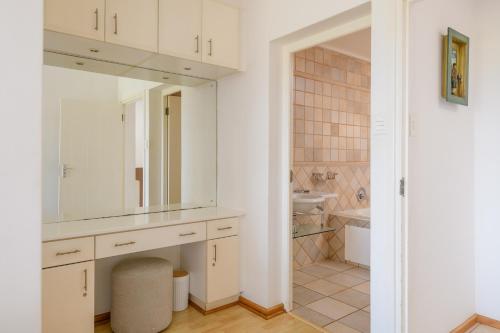 uma casa de banho branca com um lavatório e um espelho em San Lameer Villa 14108 - 4 Bedroom Classic - 8 pax - San Lameer Rental Agency em Southbroom