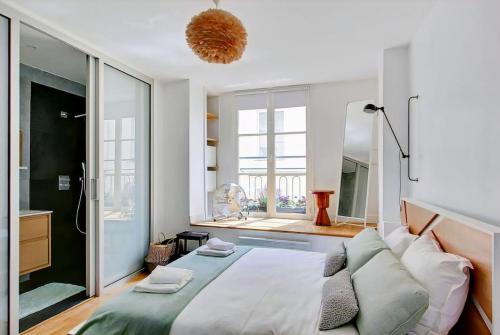 ein Schlafzimmer mit einem großen Bett und einem großen Fenster in der Unterkunft Unforgettable Stay in the Heart of Paris in Paris