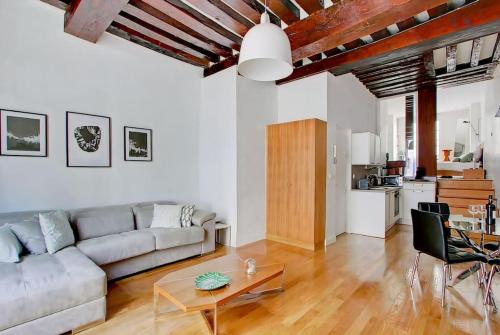 un salon avec un canapé et une table dans l'établissement Unforgettable Stay in the Heart of Paris, à Paris