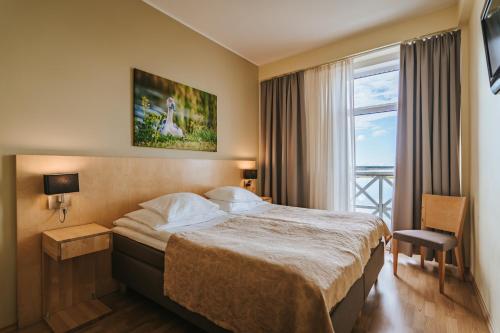 a hotel room with a bed and a window at Hestia Hotel Haapsalu SPA in Haapsalu