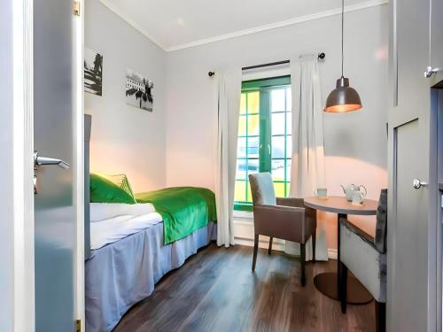 um pequeno quarto com uma cama e uma mesa em Oslo Airport Apartments em Gardermoen