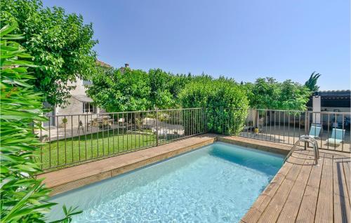 einen Pool mit einer Terrasse und einem Zaun in der Unterkunft Stunning Home In Vallabrgues With Kitchen in Vallabrègues