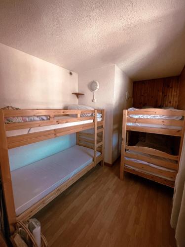 deux lits superposés dans une chambre avec parquet dans l'établissement Le cocon Risoul, à Risoul