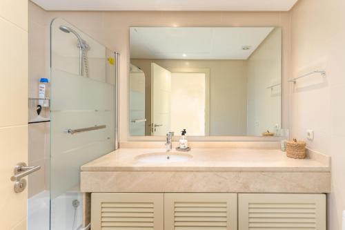 ein Bad mit einem Waschbecken und einem Spiegel in der Unterkunft Alcazaba Lagoon 2425 Luxury private beach in Estepona