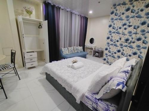 a bedroom with a bed and a blue and white curtain at Quirino Hub (401) in Davao City