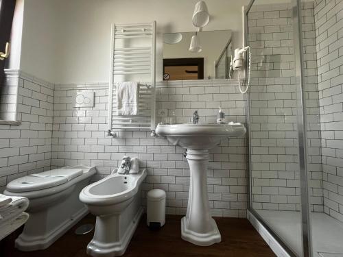 a white bathroom with a sink and a toilet at Guest House Le Vagabonde in Fiumicino