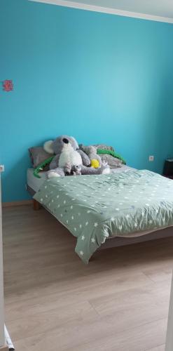 three stuffed animals sitting on a bed in a bedroom at Maison au calme in Livry-Gargan