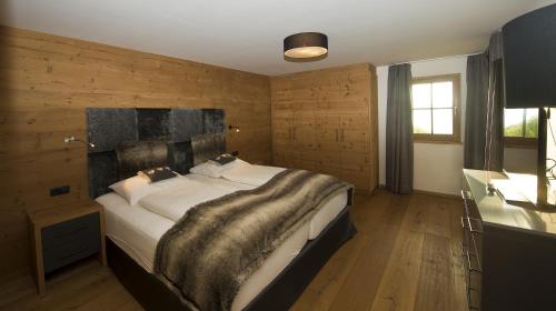 a bedroom with a large bed in a room with wooden walls at Chalet Winterbauer in Flachau